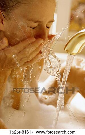 Young woman washing her face View Large Photo Image Stock Photo - Young woman washing her face. Fotosearch