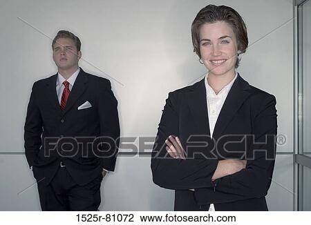Business man and business woman pose as they stand in front of camera View Large Photo Image Stock Image - Business man and business woman pose as they stand in front of camera. Fotosearch