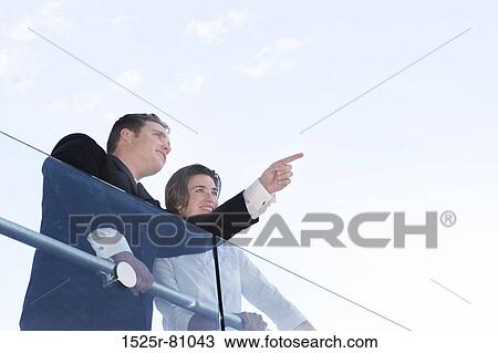 Business man and business woman stand over railing as business man points out View Large Photo Image Stock Image - Business man and business woman stand over railing as business man points out. Fotosearch