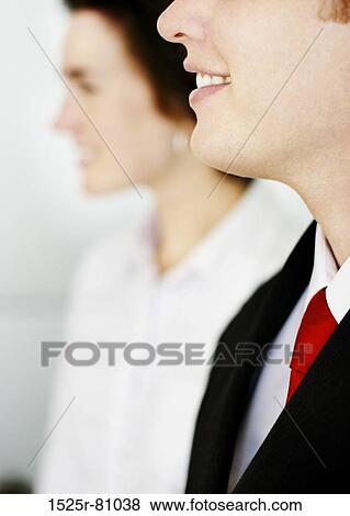 Business man in black suit and red tie smiles as he stands next to woman in white clothes View Large Photo Image Stock Photo - Business man in black suit and red tie smiles as he stands next to woman in white clothes. Fotosearch