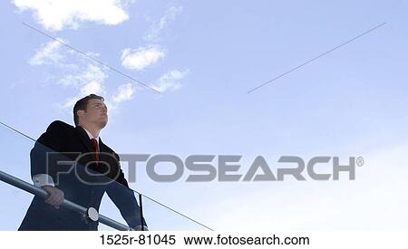 Business man in black suit and red tie stands over railing View Large Photo Image Stock Photography - Business man in black suit and red tie stands over railing. Fotosearch