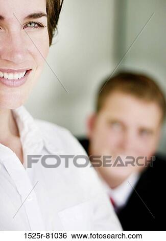 Business man in black suit smiles as he poses behind woman smiling woman dressed in white clothes View Large Photo Image Stock Photograph - Business man in black suit smiles as he poses behind woman smiling woman dressed in white clothes. Fotosearch
