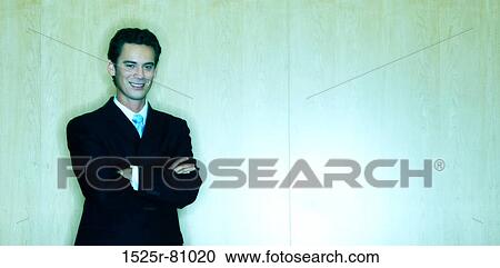Business Man stands in front of a wood background and smiles in his business suit View Large Photo Image Stock Image - Business Man stands in front of a wood background and smiles in his business suit. Fotosearch