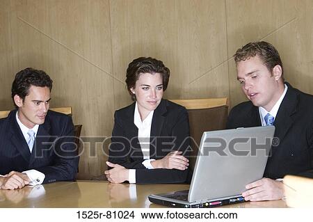 Business man teaches with his laptop two other business people View Large Photo Image Picture - Business man teaches with his laptop two other business people. Fotosearch