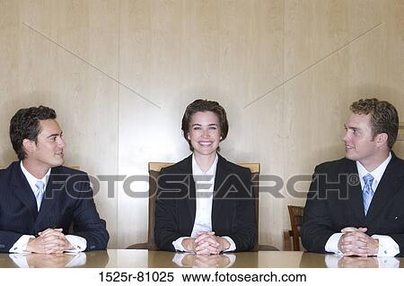 Stock Photography - Business meeting in the board room where the two business men are looking at the business woman and smiling. Fotosearch