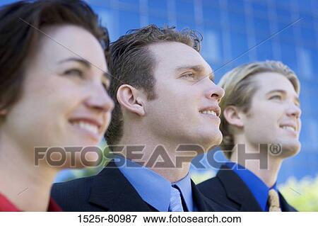 Business team looks ahead as they stand together and smile View Large Photo Image Stock Photo - Business team looks ahead as they stand together and smile. Fotosearch