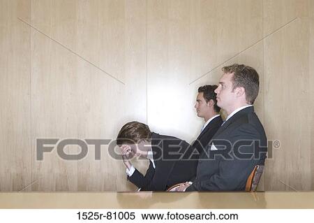 Business woman is stress as she holds her hand to her head while two other business men sit in their chairs View Large Photo Image Stock Photography - Business woman is stress as she holds her hand to her head while two other business men sit in their chairs. Fotosearch