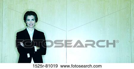 Business Woman standing with a smile in front of a wood background View Large Photo Image Stock Photo - Business Woman standing with a smile in front of a wood background. Fotosearch