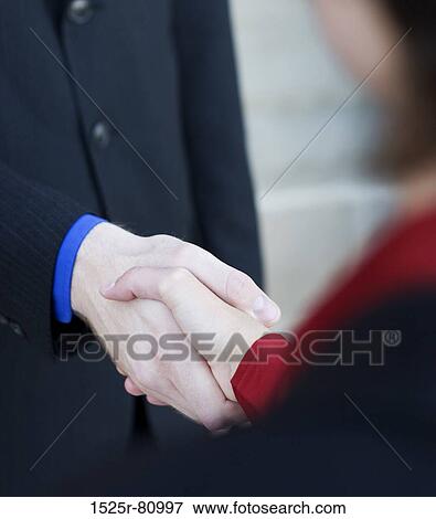 Businessman and businesswoman give each other a handshake View Large Photo Image Stock Photo - Businessman and businesswoman give each other a handshake. Fotosearch