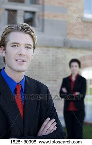 Businessman and businesswoman stand near each other with their arms folded View Large Photo Image Stock Photography - Businessman and businesswoman stand near each other with their arms folded. Fotosearch