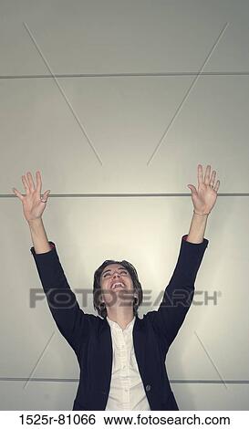 Businesswoman standing with her arms raised View Large Photo Image Stock Photograph - Businesswoman standing with her arms raised. Fotosearch