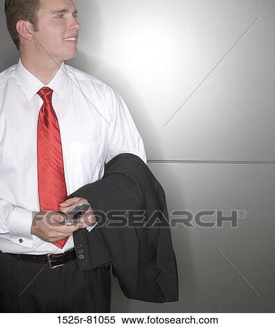 Close-up of a businessman holding a mobile phone and smiling View Large Photo Image Stock Photography - Close-up of a businessman holding a mobile phone and smiling. Fotosearch