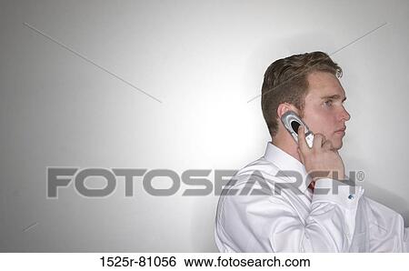 Side profile of a businessman talking on a mobile phone View Large Photo Image Stock Photograph - Side profile of a businessman talking on a mobile phone. Fotosearch