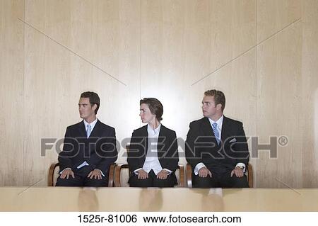 Three business people looking in the same direction while sitting together View Large Photo Image Stock Photograph - Three business people looking in the same direction while sitting together. Fotosearch
