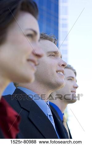 Three Business People stand together and look ahead View Large Photo Image Stock Photo - Three Business People stand together and look ahead. Fotosearch