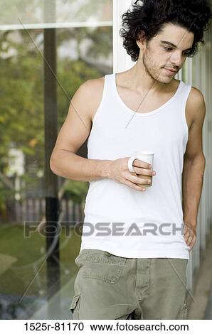 Close-up of a young man holding a cup of tea View Large Photo Image Stock Image - Close-up of a young man holding a cup of tea. Fotosearch