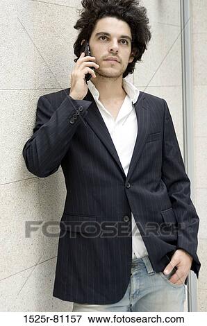 Close-up of a young man talking on a mobile phone View Large Photo Image Stock Photo - Close-up of a young man talking on a mobile phone. Fotosearch