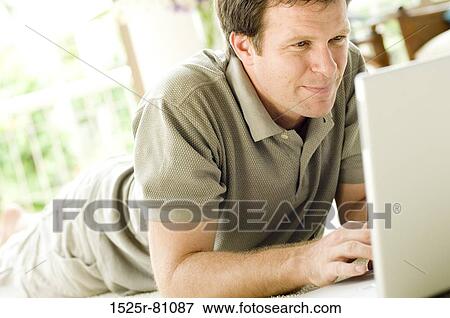 Close-up of a young man using a laptop View Large Photo Image Stock Photo - Close-up of a young man using a laptop. Fotosearch
