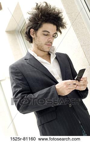 Stock Image - Close-up of a young man using a mobile phone. Fotosearch