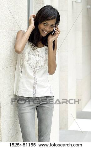 Close-up of a young woman talking on a mobile phone View Large Photo Image Stock Photography - Close-up of a young woman talking on a mobile phone. Fotosearch
