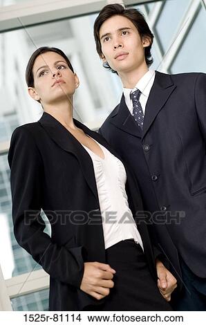 Low angle view of a businessman and a businesswoman standing together in front of a window View Large Photo Image Picture - Low angle view of a businessman and a businesswoman standing together in front of a window. Fotosearch