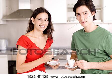 Portrait of a young couple in the kitchen and holding cups of tea View Large Photo Image Stock Photography - Portrait of a young couple in the kitchen and holding cups of tea. Fotosearch