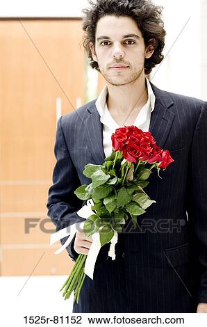 Portrait of a young man holding a bouquet of roses View Large Photo Image Stock Image - Portrait of a young man holding a bouquet of roses. Fotosearch