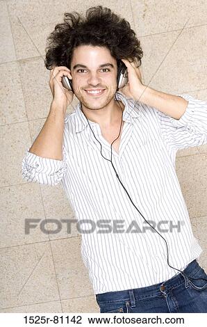 Portrait of a young man wearing headphones and smiling View Large Photo Image Stock Image - Portrait of a young man wearing headphones and smiling. Fotosearch