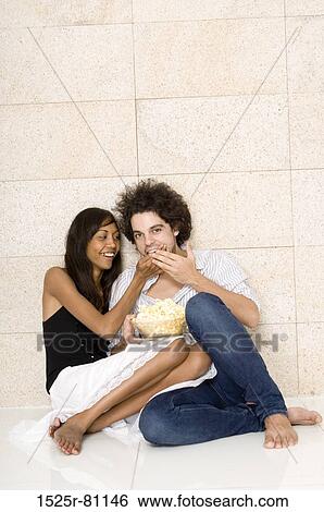 Young woman feeding popcorn to a young man View Large Photo Image Stock Photograph - Young woman feeding popcorn to a young man. Fotosearch