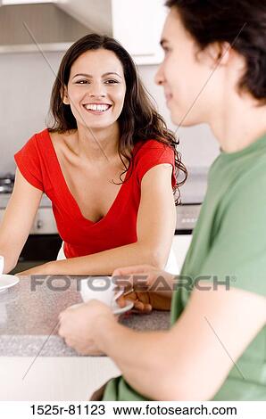 Young woman looking at a young man and smiling View Large Photo Image Stock Image - Young woman looking at a young man and smiling. Fotosearch