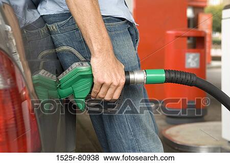 Close-up of a man refueling a car View Large Photo Image Stock Photo - Close-up of a man refueling a car. Fotosearch