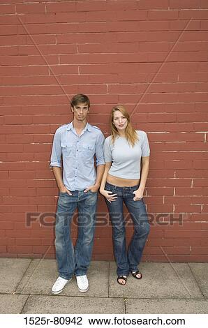 Portrait of a young couple leaning against a wall View Large Photo Image Stock Image - Portrait of a young couple leaning against a wall. Fotosearch