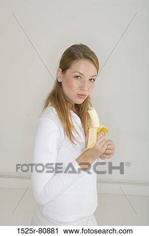 Portrait of a young woman eating a banana View Large Photo Image Stock Image - Portrait of a young woman eating a banana. Fotosearch