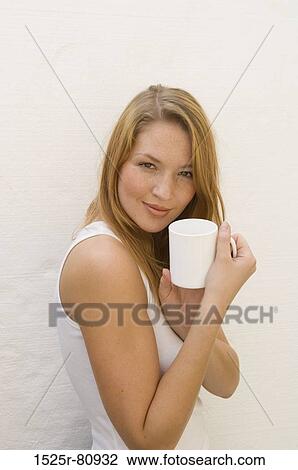 Portrait of a young woman holding a mug View Large Photo Image Stock Image - Portrait of a young woman holding a mug. Fotosearch