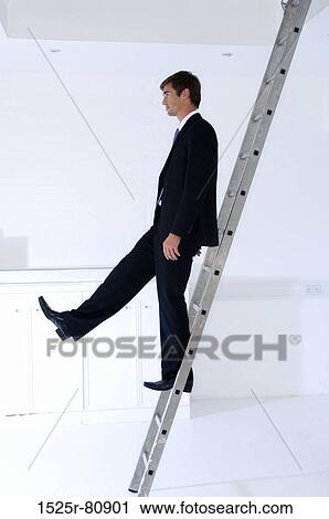 Side profile of a businessman moving down a ladder View Large Photo Image Stock Image - Side profile of a businessman moving down a ladder. Fotosearch