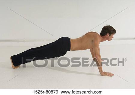 Stock Photo - Side profile of a young man doing push-ups. Fotosearch