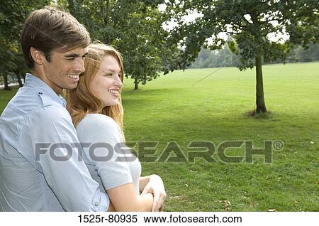 Side profile of a young man embracing a young woman from behind in a park View Large Photo Image Stock Photography - Side profile of a young man embracing a young woman from behind in a park. Fotosearch