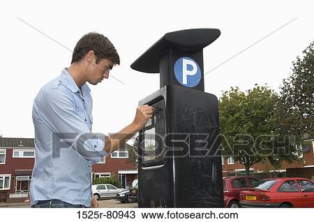 Side profile of a young man using a parking meter in a parking lot View Large Photo Image Stock Image - Side profile of a young man using a parking meter in a parking lot. Fotosearch