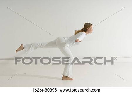 Side profile of a young woman exercising View Large Photo Image Stock Photograph - Side profile of a young woman exercising. Fotosearch