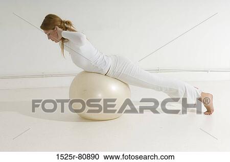 Side profile of a young woman exercising on a fitness ball View Large Photo Image Stock Image - Side profile of a young woman exercising on a fitness ball. Fotosearch