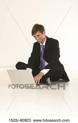 Young man using a laptop and smiling View Large Photo Image Stock Image - Young man using a laptop and smiling. Fotosearch