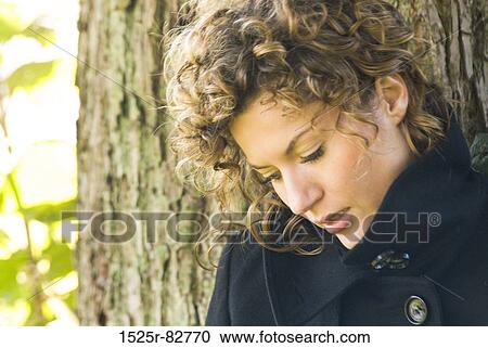 Close-up of a young woman thinking View Large Photo Image Stock Image - Close-up of a young woman thinking. Fotosearch