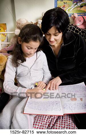 Girl with her mother studying on the bed View Large Photo Image Stock Photography - Girl with her mother studying on the bed. Fotosearch