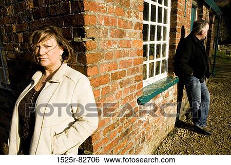 Stock Photograph - Mature couple leaning against walls of a house. Fotosearch