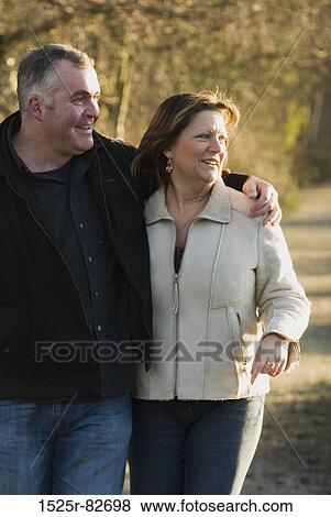 Mature couple walking together and smiling View Large Photo Image Stock Photo - Mature couple walking together and smiling. Fotosearch