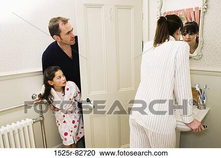 Mid adult man with his daughter peeking at teenage girl standing in front of a mirror View Large Photo Image Stock Image - Mid adult man with his daughter peeking at teenage girl standing in front of a mirror. Fotosearch