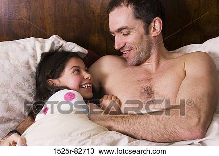 Mid adult man with his daughter smiling in the bed View Large Photo Image Stock Image - Mid adult man with his daughter smiling in the bed. Fotosearch
