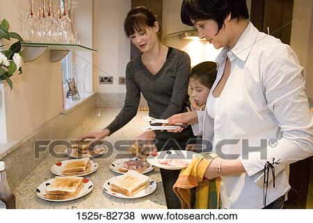 Mid adult woman with her two daughters preparing sandwiches View Large Photo Image Stock Photo - Mid adult woman with her two daughters preparing sandwiches. Fotosearch