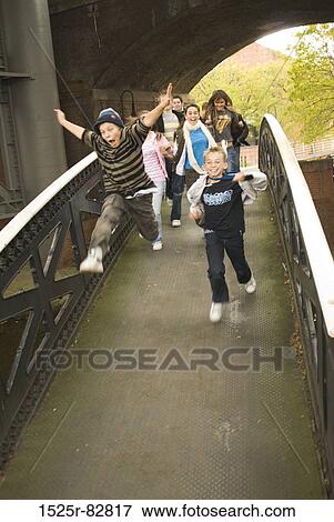Teenage boys and teenage girls running on a bridge View Large Photo Image Stock Photo - Teenage boys and teenage girls running on a bridge. Fotosearch