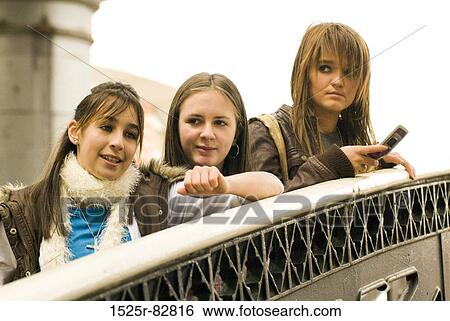 Three teenage girls standing near a railing View Large Photo Image Stock Photograph - Three teenage girls standing near a railing. Fotosearch